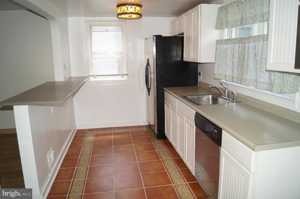 3113 Offutt Road Randallstown, MD 21133 - Photo 4 of 14 a kitchen with a sink a refrigerator and a window