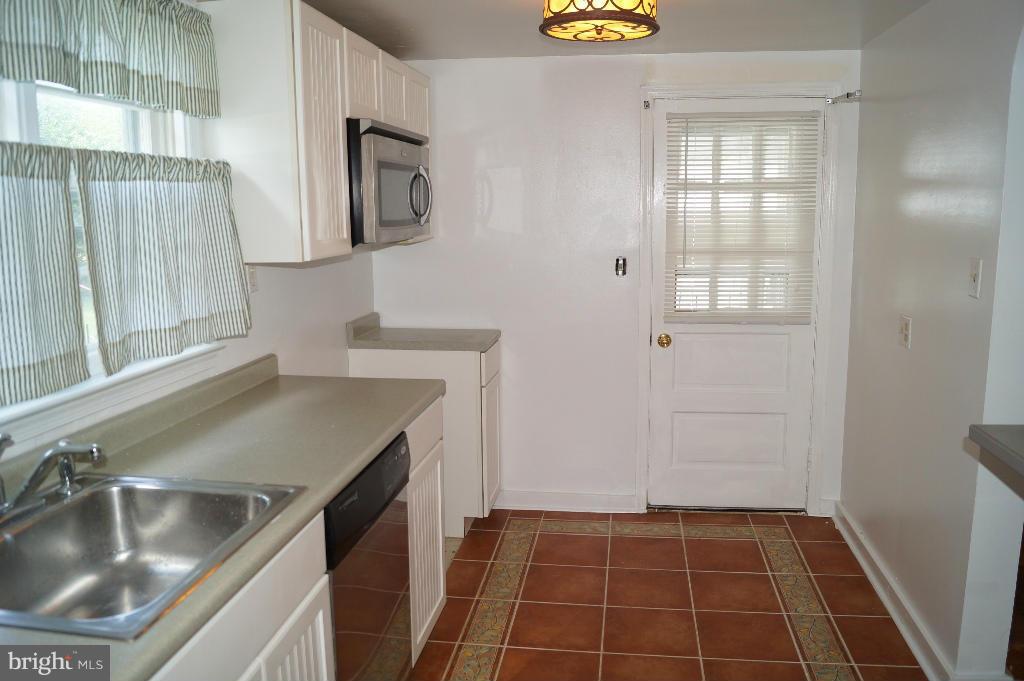 3113 Offutt Road Randallstown, MD 21133 - Photo 5 of 14 a kitchen with a sink stove and cabinets