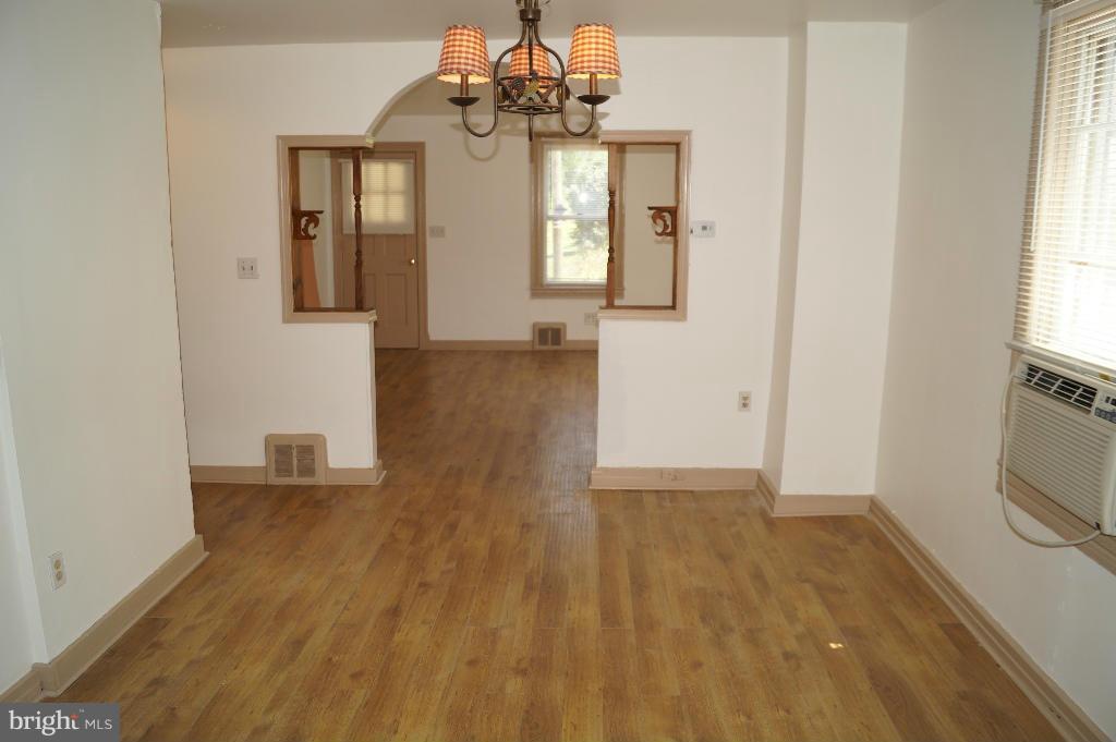 3113 Offutt Road Randallstown, MD 21133 - Photo 7 of 14 a view of a hallway with wooden floor and a chandelier