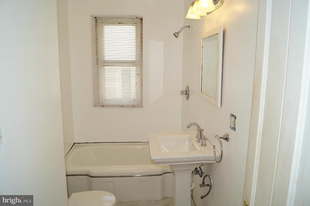 3113 Offutt Road Randallstown, MD 21133 - Photo 9 of 14 a bathroom with a toilet sink and mirror