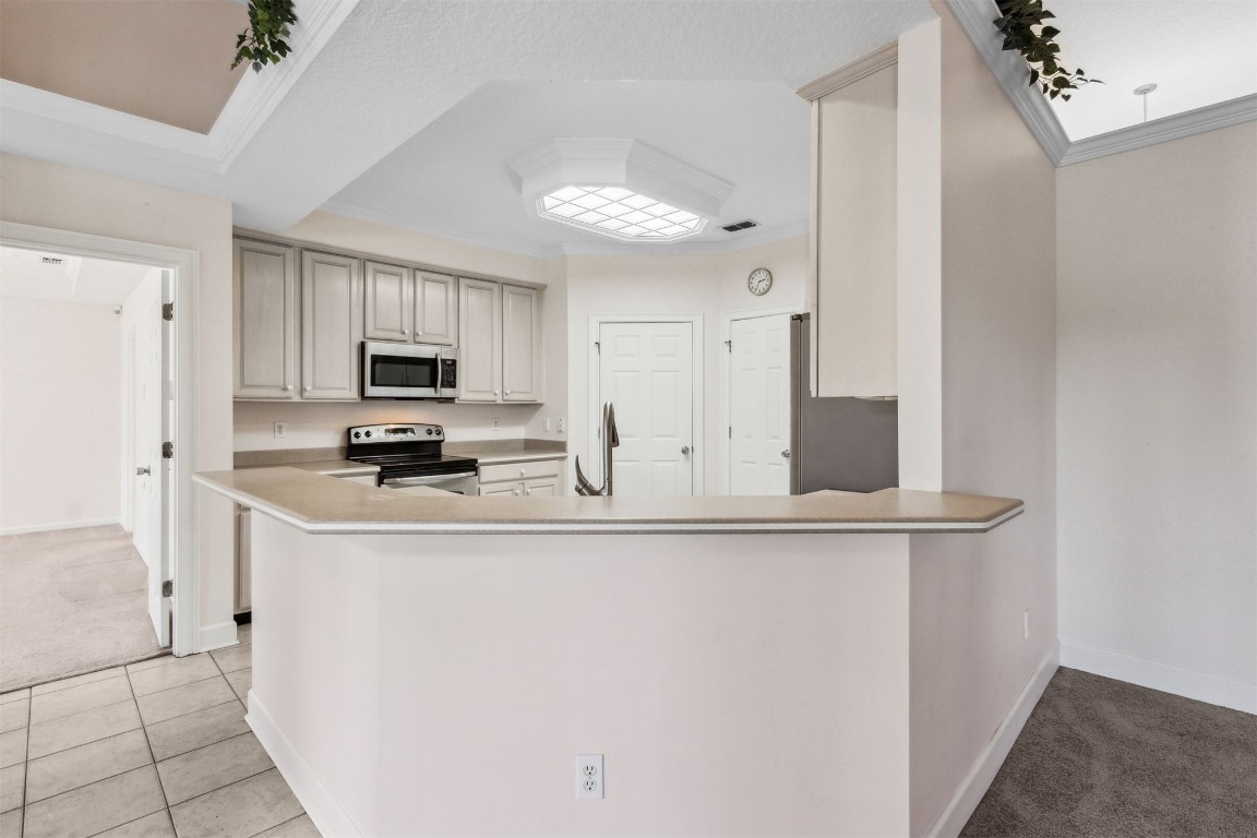 86305 Meadowfield Bluffs Road Yulee, FL 32097 - Photo 17 of 33 a kitchen with stainless steel appliances a refrigerator sink stove and white cabinets