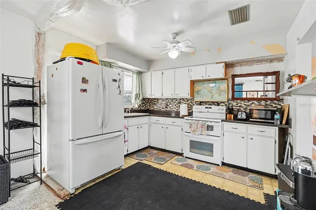 a kitchen with stainless steel appliances a refrigerator sink and cabinets