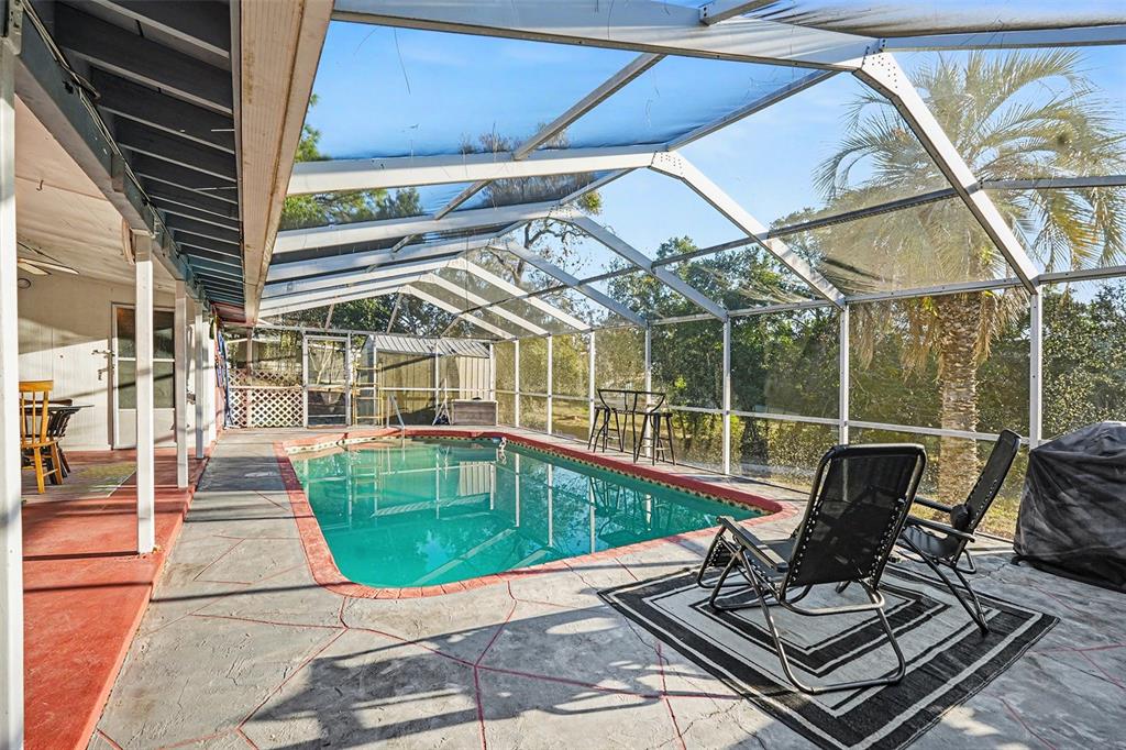 6686 Treehaven Drive Spring Hill, FL 34606 - Photo 24 of 29 a view of a patio with a table chairs and barbeque