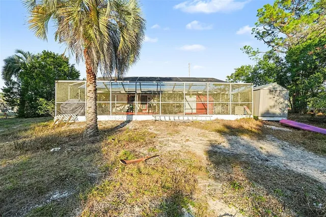 a view of a house with backyard and tree