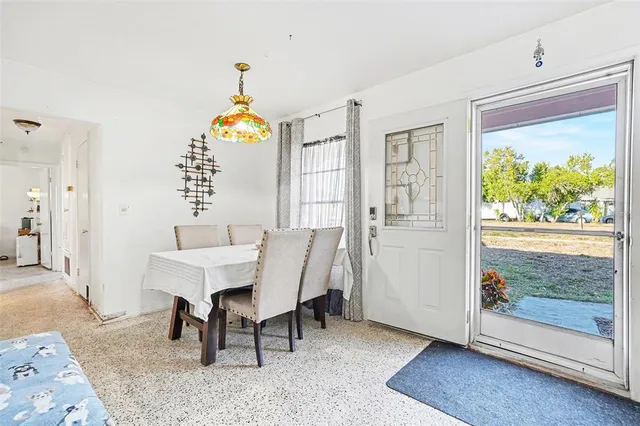 a dining room with wooden floor a chandelier a wooden table and chairs