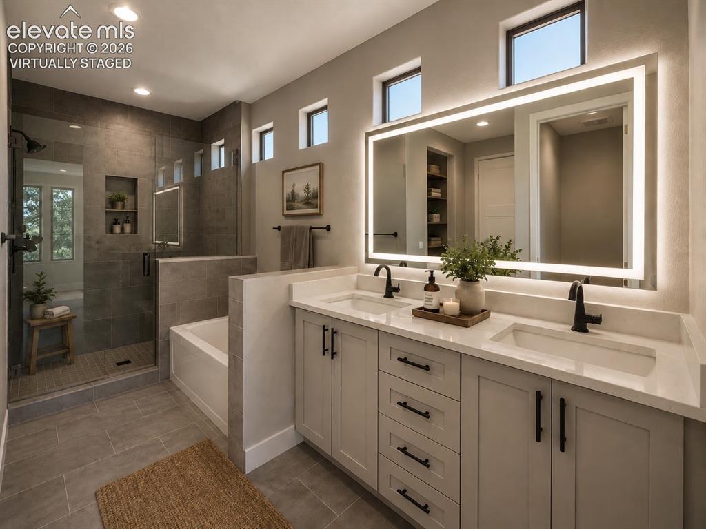 3145 Promise Point Colorado Springs, CO 80921 - Photo 11 of 28 Primary Bathroom with Double Vanities, Quartz Countertops, Heated and Lighted Mirror, Soaking Tub, and Shower with Bench. Virtually Staged.