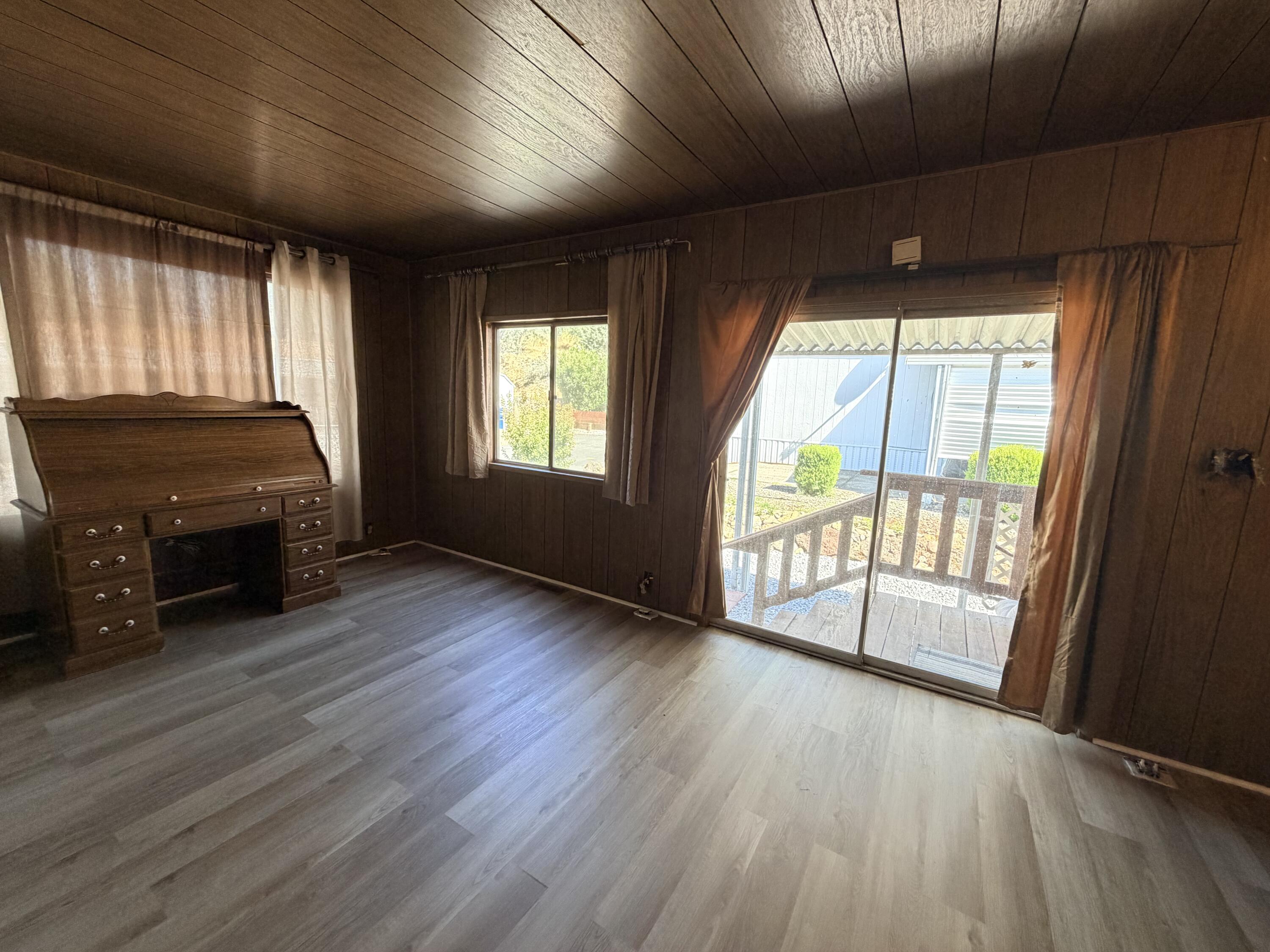 1449 Menomenee Lane, Unit 252 Redding, CA 96003 - Photo 11 of 18 a view of an empty room with a window and wooden floor