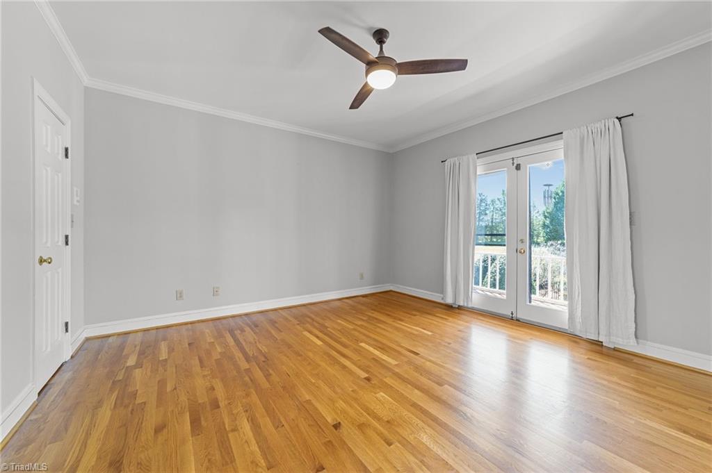 130 Deer Path Summerfield, NC 27358 - Photo 19 of 50 Primary bedroom with ceiling fan and door that leads to the back deck.