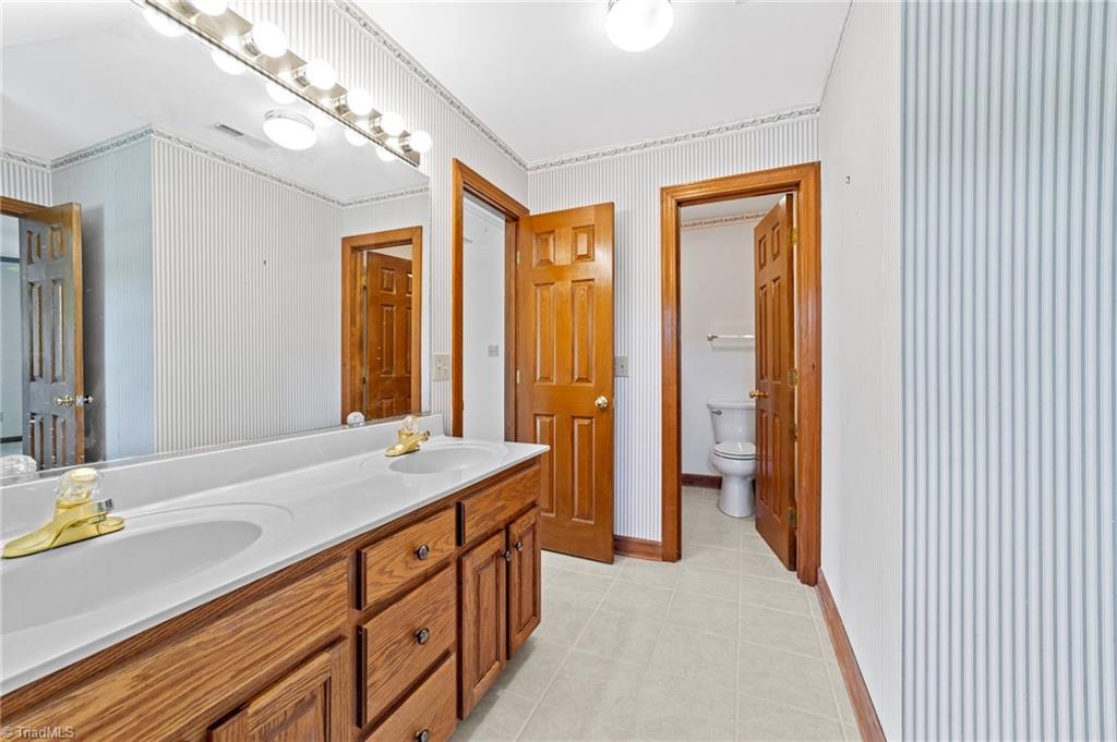130 Deer Path Summerfield, NC 27358 - Photo 27 of 50 Full bathroom with double sink and vanity mirror.