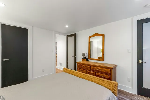 a bedroom with a bed and a large mirror on dresser