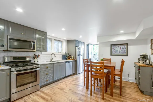 a large kitchen with stainless steel appliances a stove a dining table and chairs
