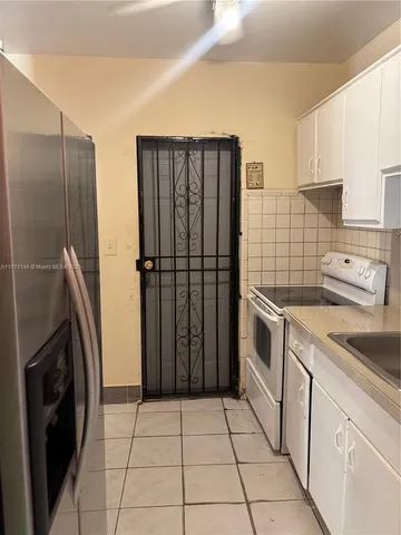 a kitchen with a refrigerator sink and cabinets