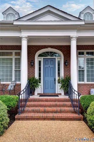 a front view of a house with potted plants and wooden fence