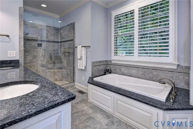 a bathroom with a granite countertop double vanity sink mirror and a bathtub
