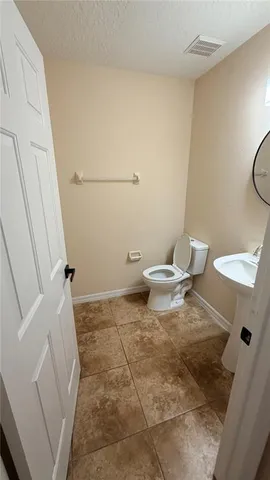 a bathroom with a granite countertop sink and a toilet