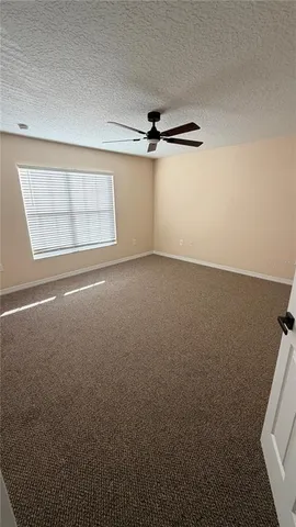 an empty room with windows and fan