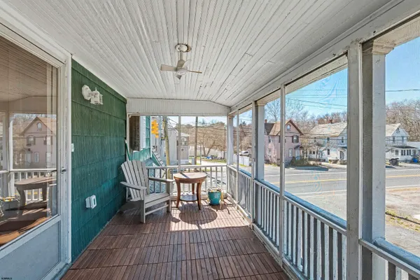 a view of a porch with furniture and wooden floor