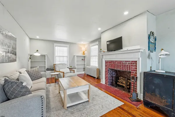 a living room with furniture a flat screen tv and a fireplace