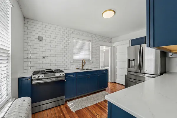 a kitchen with stainless steel appliances granite countertop a refrigerator stove and sink