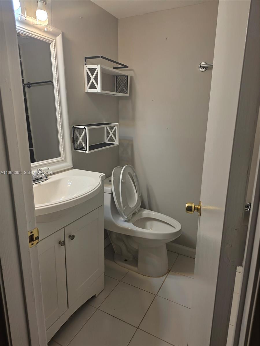 9500 Southwest 3rd Street, Unit 259 Boca Raton, FL 33428 - Photo 5 of 10 a bathroom with a toilet a sink and mirror