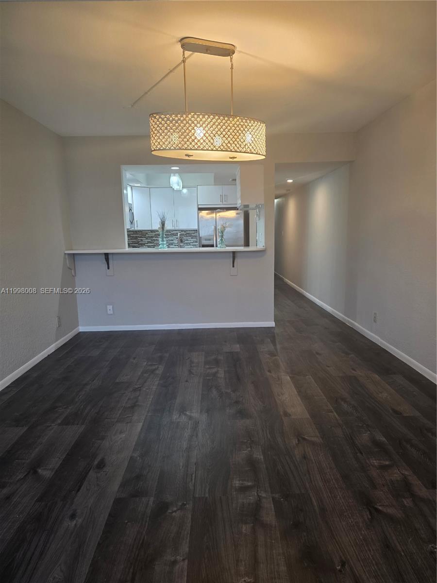 9500 Southwest 3rd Street, Unit 259 Boca Raton, FL 33428 - Photo 8 of 10 an empty room with wooden floor and windows