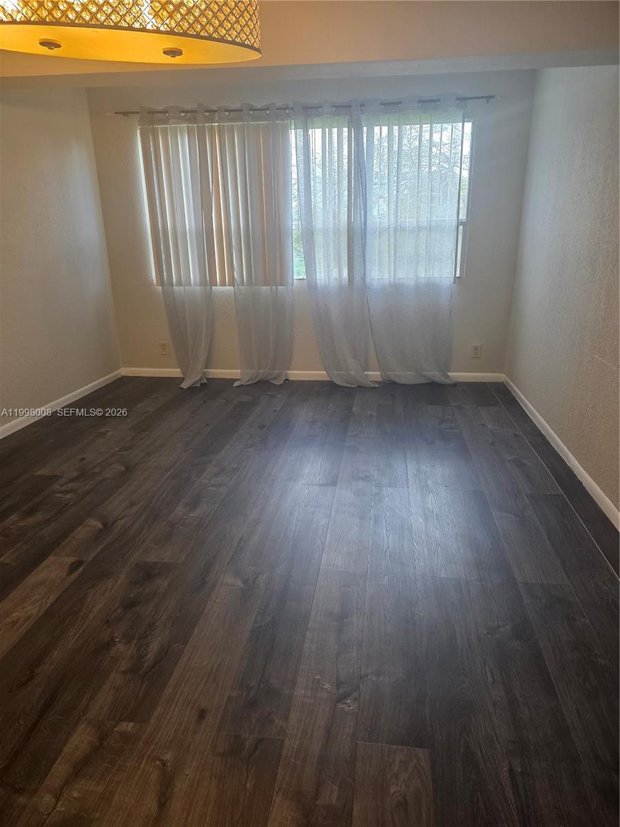 9500 Southwest 3rd Street, Unit 259 Boca Raton, FL 33428 - Photo 10 of 10 an empty room with wooden floor and windows
