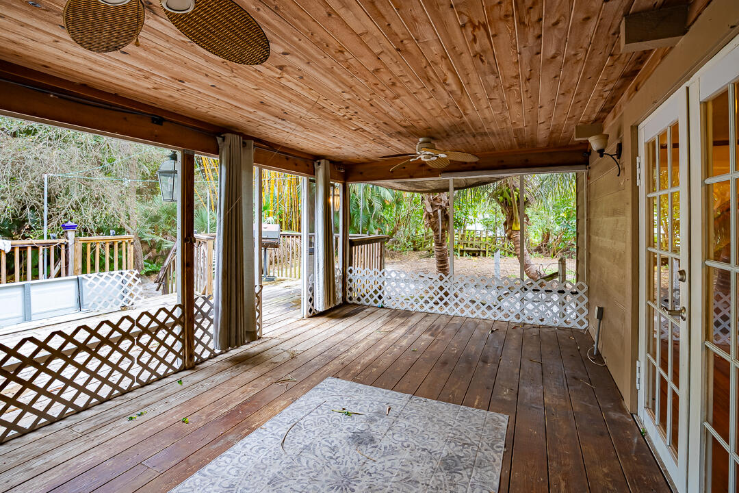 5503 Raintree Trail Fort Pierce, FL 34982 - Photo 25 of 34 a view of porch with wooden floor and floor to ceiling window