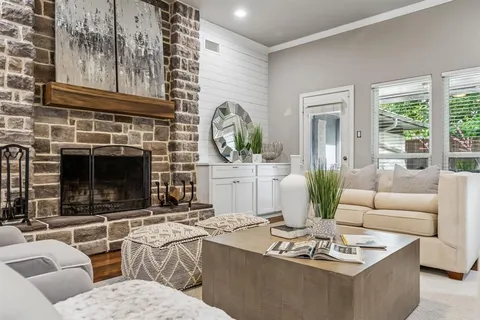 a living room with furniture a fireplace and a potted plant