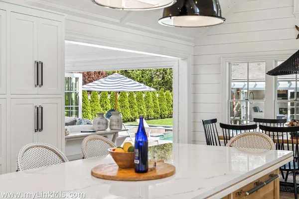 a view of a dining room and kitchen with a table chairs
