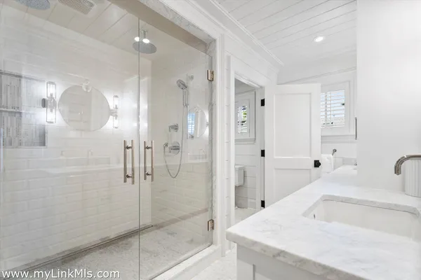 a bathroom with a bathtub sink and mirror