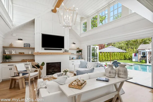 a living room with furniture fireplace and a large window