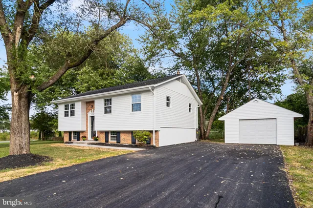 a view of a house with a yard and large tree