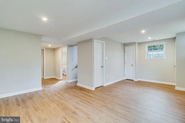 a view of an empty room with wooden floor and entryway