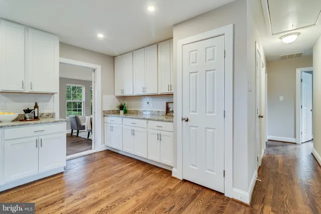 a kitchen with granite countertop white cabinets and white appliances