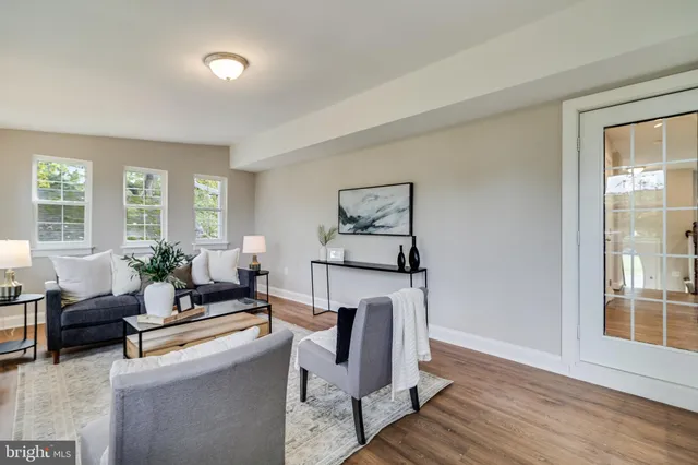 a living room with furniture a large window and a wooden floor