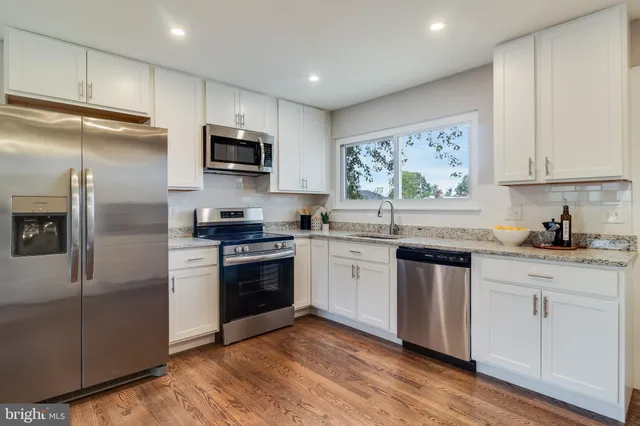 a kitchen with stainless steel appliances granite countertop a refrigerator sink and microwave