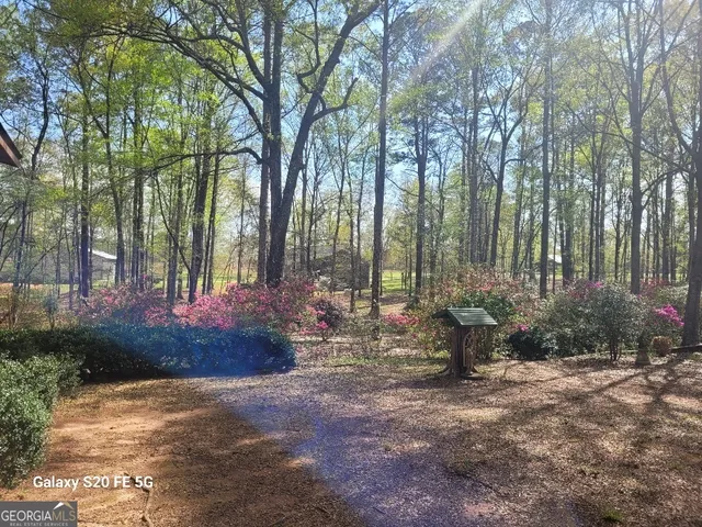 a view of a house with a yard and sitting area