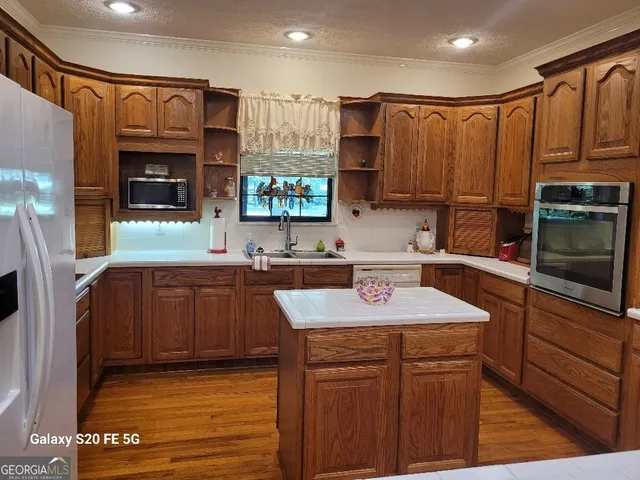 a kitchen with stainless steel appliances granite countertop a sink stove and microwave