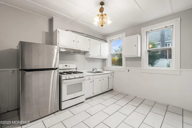 a kitchen with a refrigerator sink and cabinets