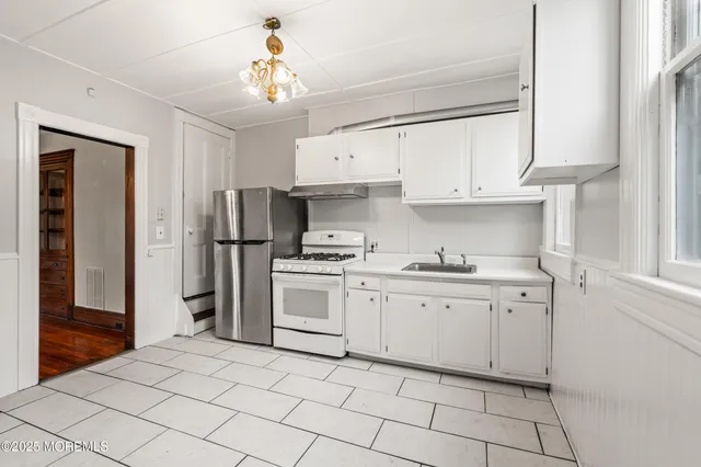a kitchen with white cabinets and appliances