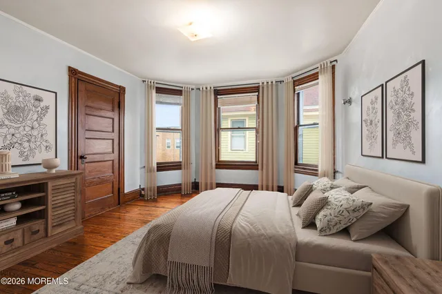 a bedroom with a bed and wooden floor