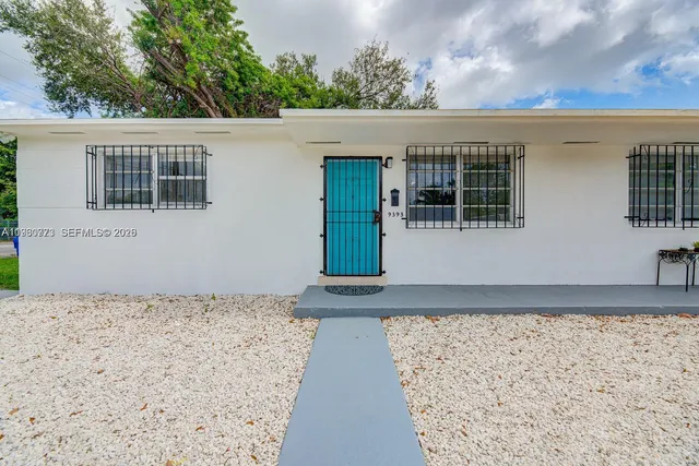 a view of a house with a yard and potted plants