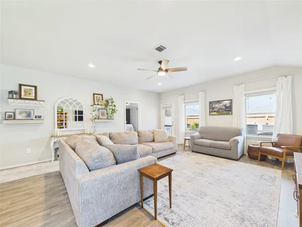 a living room with furniture and a wooden floor