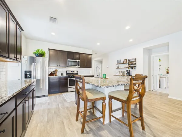 a view of a dining room with furniture a kitchen and chandelier