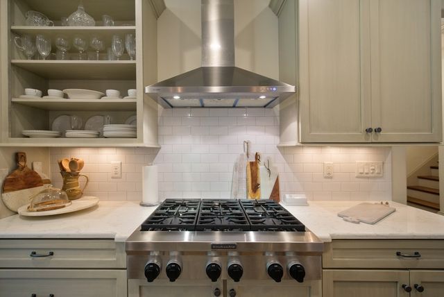 a kitchen with white cabinets and stainless steel appliances