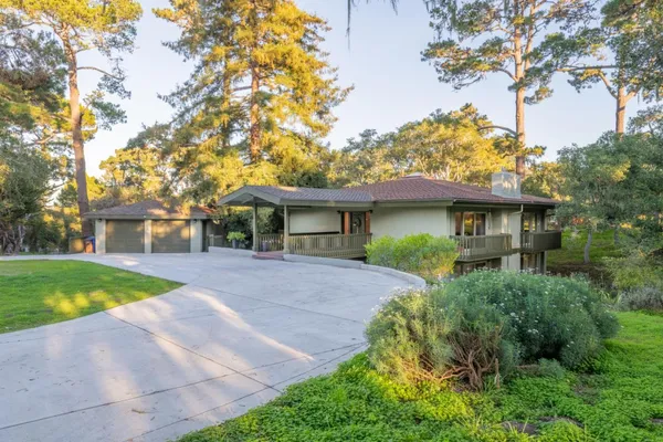 a front view of a house with a yard and trees