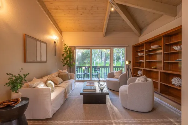 a living room with furniture and a floor to ceiling window
