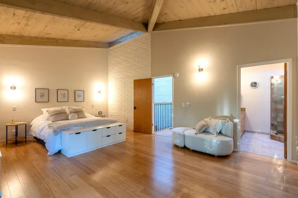 a bed sitting in a spacious bedroom next to a window