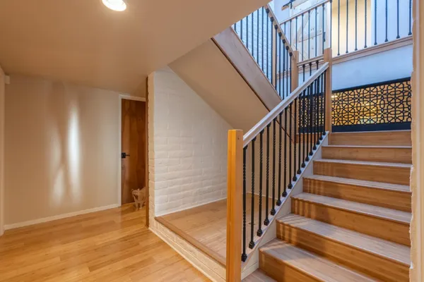 a view of a hallway with wooden floor and entryway