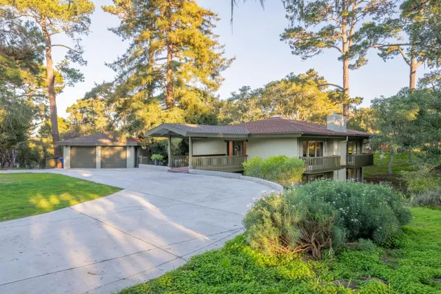 a front view of a house with a yard and trees